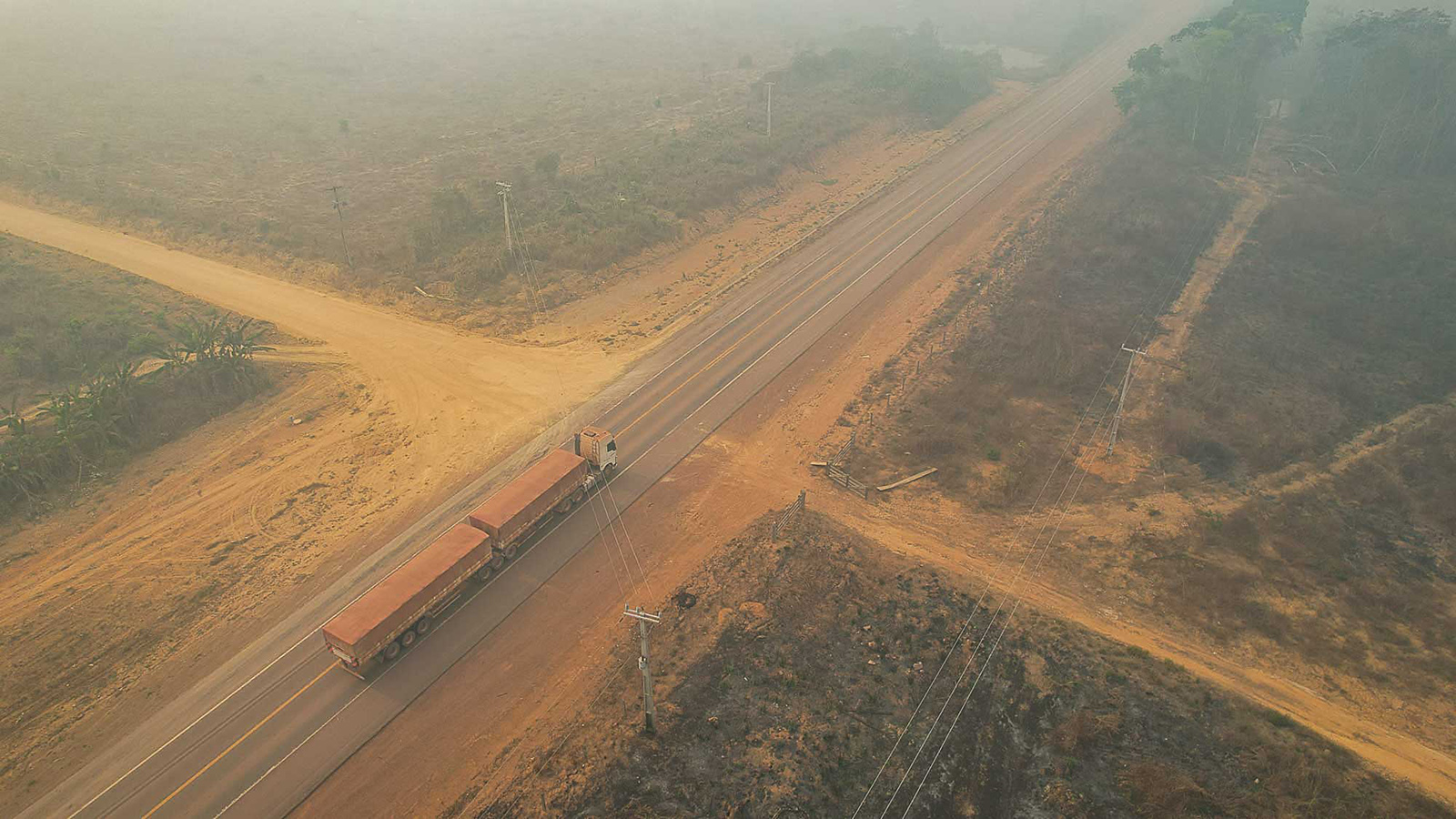 A truck carrying soybeans surrounded by smoke from fires in a deforested area on the BR-163 highway in Pará state. Image courtesy of Alberto César Araújo/Amazônia Real.