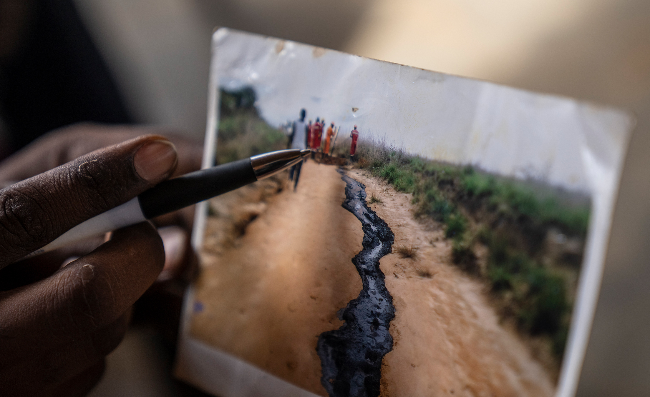 A man displays a photo he says shows toxic chemicals spilled due to oil drilling, in Moanda, western Democratic Republic of Congo, 2023. Image is unrelated to the story and used for representation purpose only. Image by AP Photo/Mosa'ab Elshamy.