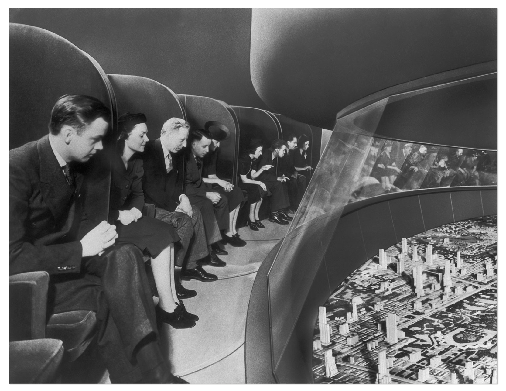 Image via Grist Photo of people peering over at a futuristic model city below — Image via Grist