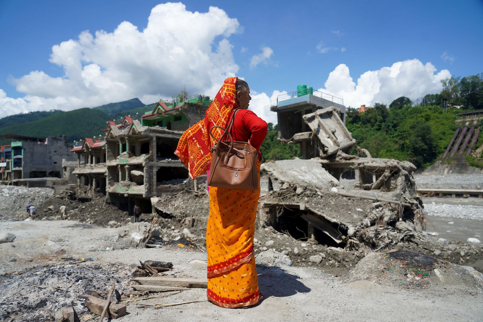 A woman stands near homes damaged by flash floods in Dhunge Bazar, Nuwakot district, Nepal, on 12 September 2026. Credit: Aryan Dhimal / Alamy Stock Photo