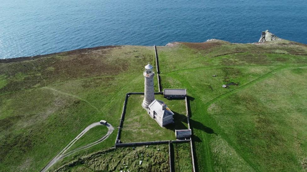 An aerial view of Lundy Island's lighthouse on the coastline.