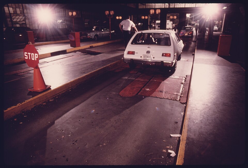 CAR THAT HAS JUST BEEN THROUGH AN EXHAUST ANALYZER TEST FOR CARBON MONOXIDE AND HYDROCARBON EMISSIONS CONTINUES DOWN... - NARA - 557887.jpg
