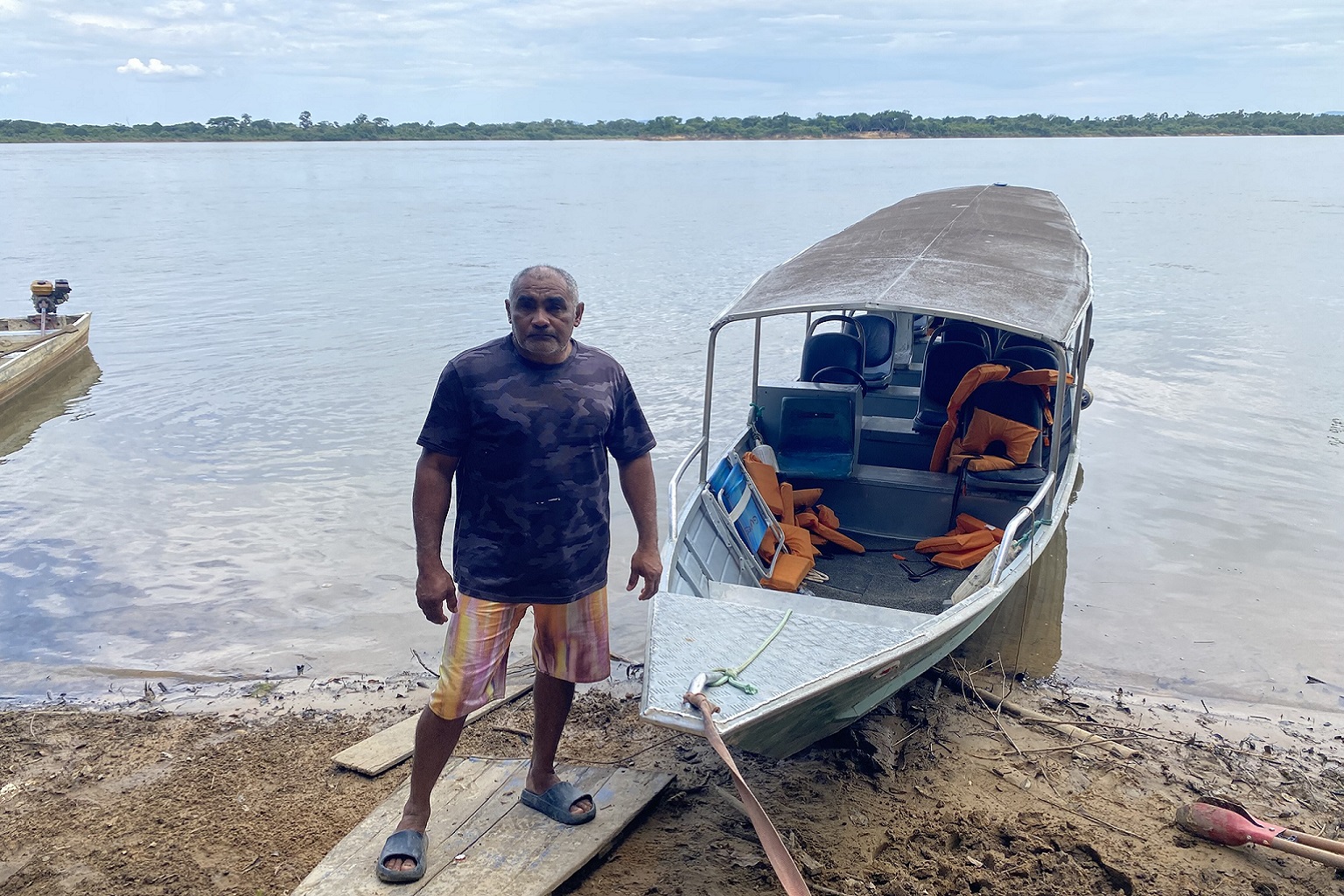 Image by Felipe Medeiros. Tour guide Fredson Guedes, known as "Tarzan," stands in front of the boat he uses to take visitors to the Véu de Noiva waterfall in Cantá, Roraima. — Image by Felipe Medeiros.