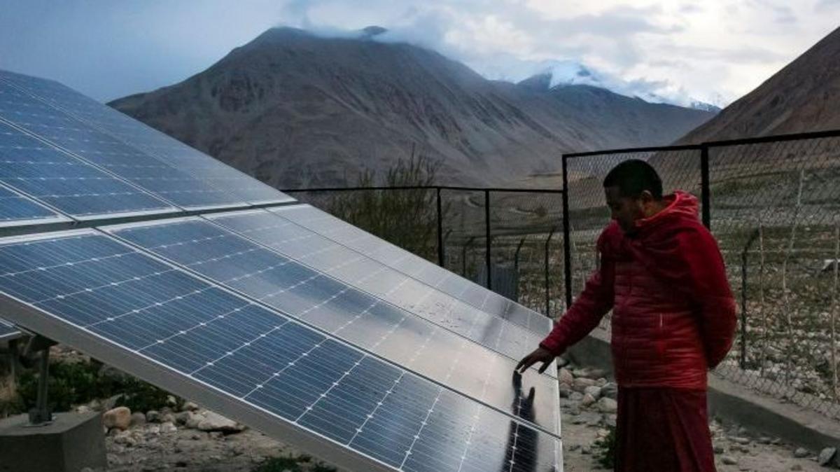 A monk touches solar panels at the Shachukul Monastery in the Ladakh region