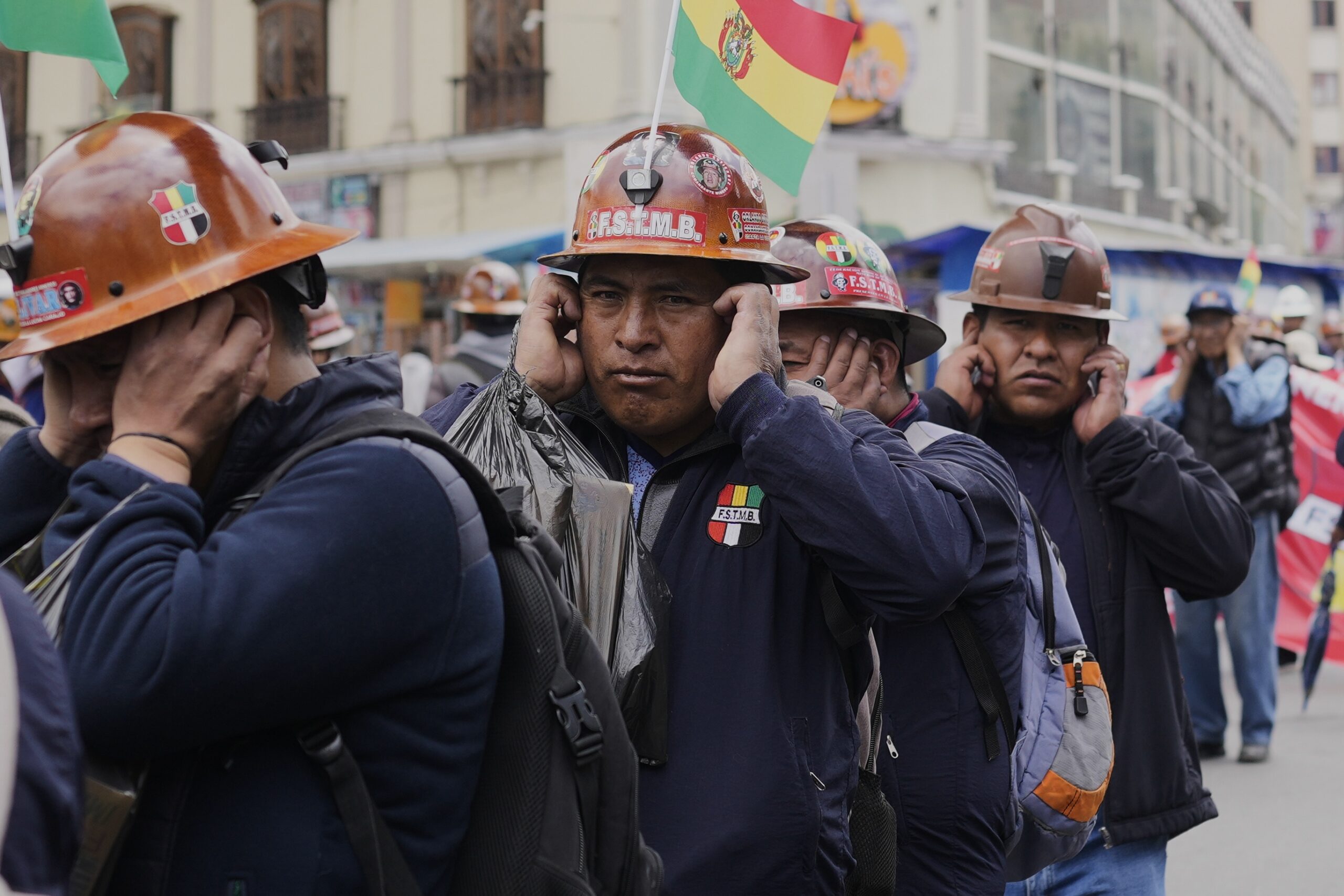 State miners cover their ears while detonating dynamite during a march against illegal mining, alleging that independent miners are encroaching on their work areas, in La Paz, Bolivia, Thursday, Sept. 18, 2025. (AP Photo/Juan Karita)