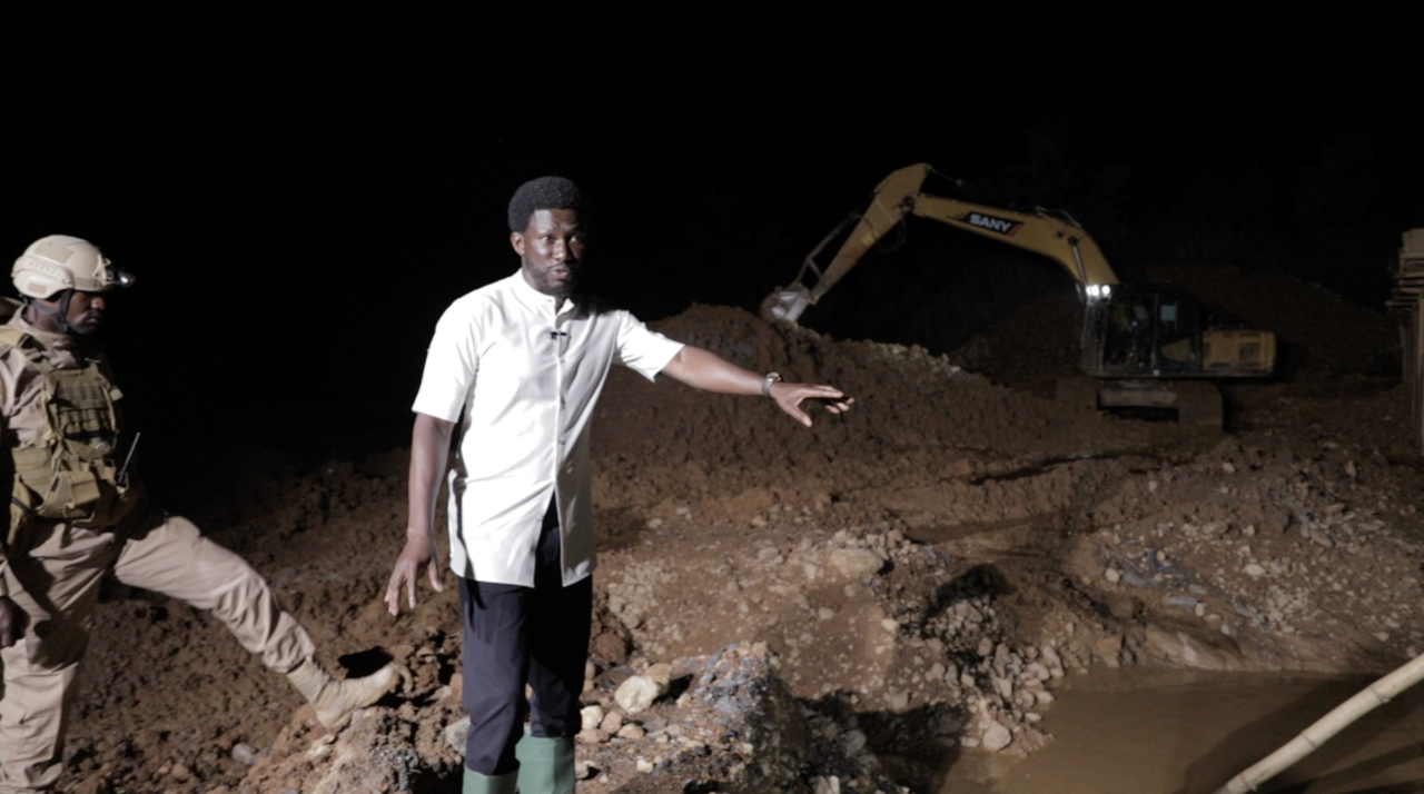 A journalist with law enforcement officials at an illegal mine site in Ghana in 2024. Image by Paadebrah via Wikicommons (CC 0 1.0) https://commons.wikimedia.org/wiki/File:NKB_Galamsey.png https://creativecommons.org/publicdomain/zero/1.0/deed.en