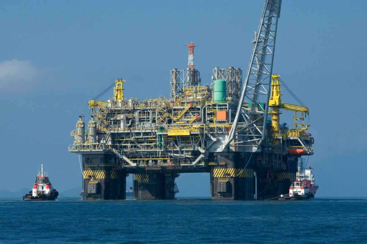 An exploration platform of Brazil’s state-owned oil firm Petrobras, between two vessels. Image by Agência Brasil via Wikimedia Commons. (CC BY-SA 4.0).