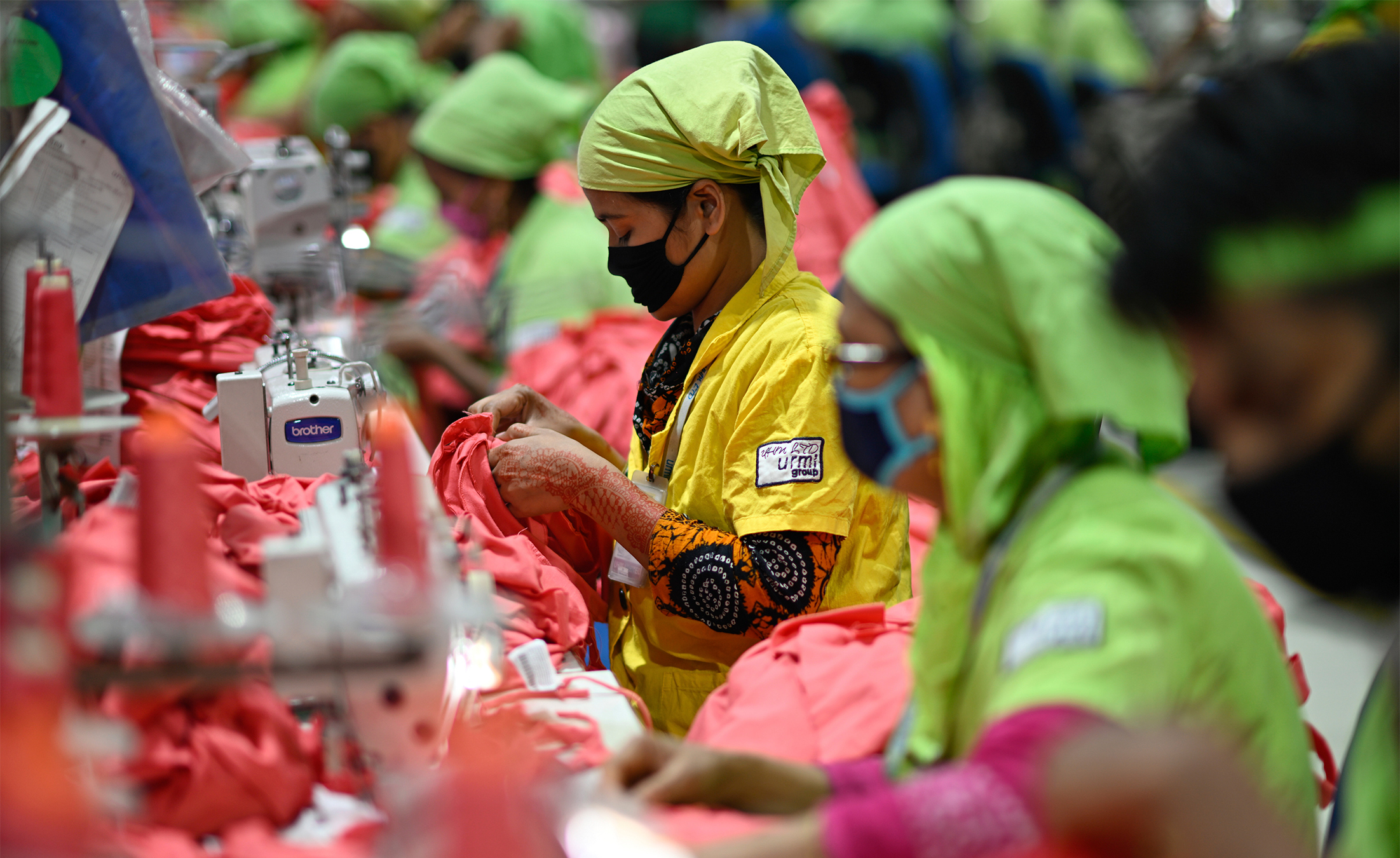 Factory workers operate machines to make garments at UHM Ltd. in Narayaganj, Bangladesh, 2025. Image by AP Photo/Mahmud Hossain Opu.
