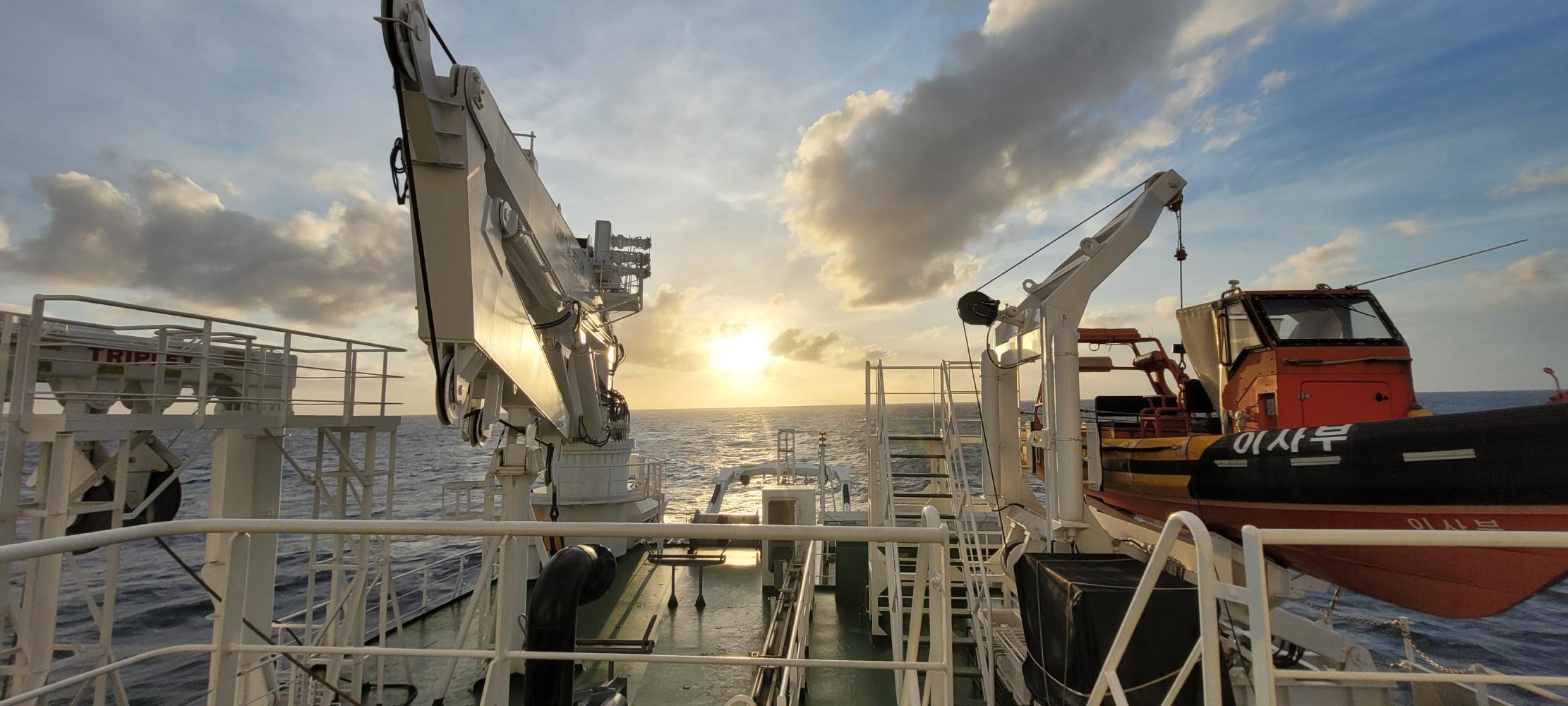 The deck of the research vessel Isabu at sea at sunset.