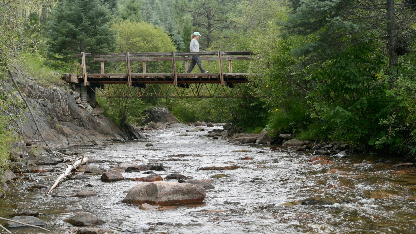 A hiker crosses a bridge over the Pecos River in northern New Mexico.