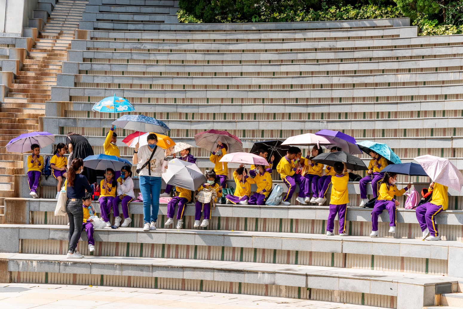 Schoolchildren using umbrellas to shelter from the sun in Hong Kong. Credit: Grant Rooney / Alamy Stock Photo